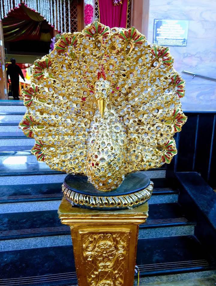 Golden peacock artwork at the entrance of the bhawan